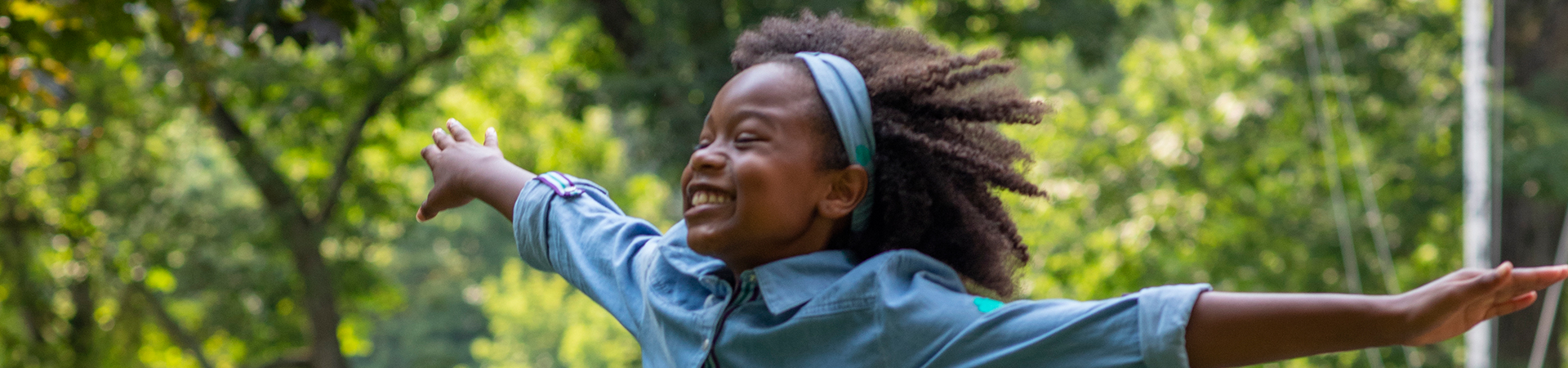  girl scout staff or volunteer wearing adult vest in woods smiling 